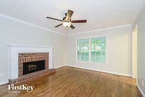 Clemmons house for rent - a living room with a brick fireplace and a ceiling fan