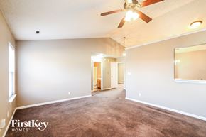 Indianapolis house for rent - A spacious room with a ceiling fan and a carpeted floor.