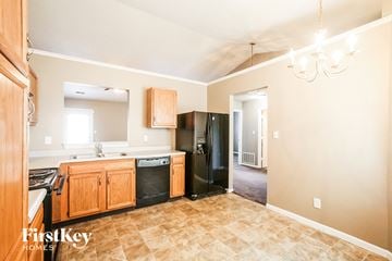 Indianapolis house for rent - A kitchen with wooden cabinets and a black refrigerator.