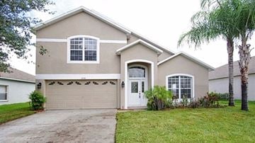 Orlando house for rent - A house with a white garage door and a brown roof.