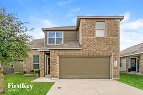 Bulverde house for rent - a tan brick house with a garage door