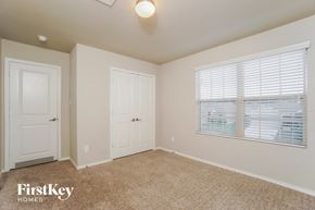 Bulverde house for rent - a bedroom with beige carpet and a window and white doors