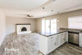 Glendale house for rent - A spacious kitchen and living room with a fireplace and a ceiling fan.