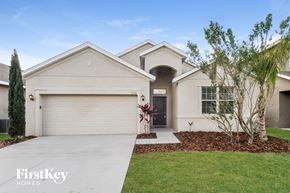 Lakeland house for rent - a white house with a driveway and a garage door