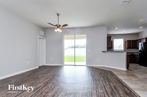 Lakeland house for rent - an empty living room with a kitchen and a ceiling fan