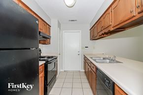 Memphis house for rent - a kitchen with wood cabinets and white counter tops and black appliances