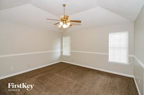 Memphis house for rent - a bedroom with a carpeted floor and a ceiling fan