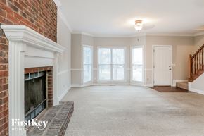 Powder Springs house for rent - a living room with a brick fireplace and a carpeted floor