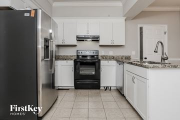 Powder Springs house for rent - a kitchen with white cabinets and a stove and a refrigerator