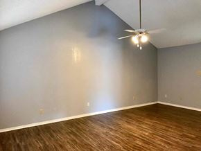 Garland house for rent - a living room with wood floors and a ceiling fan