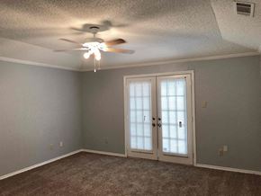 Garland house for rent - a bedroom with a ceiling fan and a door to a closet