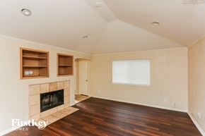 Dallas house for rent - A living room with a fireplace and wooden floors.