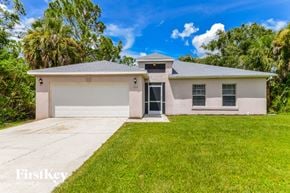 North Port house for rent - a white house with a lawn and a garage