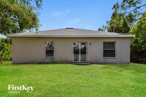 North Port house for rent - a small white house with a lawn and trees