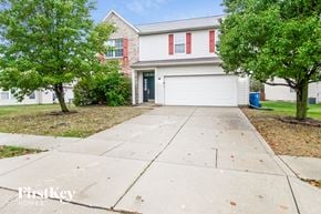 Indianapolis house for rent - A house with a red brick wall and a white garage door.