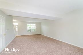 Indianapolis house for rent - A room with a carpeted floor and a door on the left side.