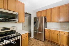 Indianapolis house for rent - A kitchen with wooden cabinets and a stainless steel refrigerator.