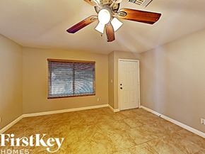 Glendale house for rent - an empty living room with a ceiling fan and a door