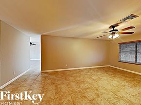 Glendale house for rent - an empty living room with a ceiling fan and tile floor