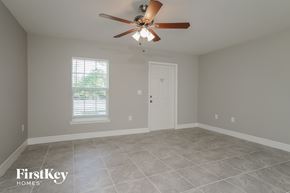 Lehigh Acres house for rent - an empty room with a ceiling fan and a door