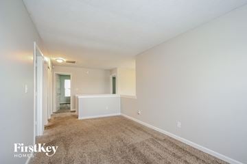 Indianapolis house for rent - a spacious living room with carpet and white walls