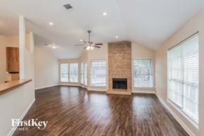 Houston house for rent - A spacious living room with wood flooring and a fireplace.