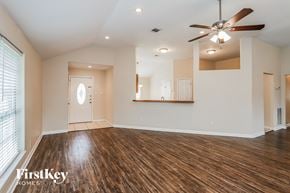 Houston house for rent - A spacious room with wooden floors and a ceiling fan.
