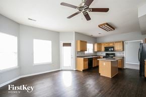 Indianapolis house for rent - an empty kitchen with wood floors and a ceiling fan