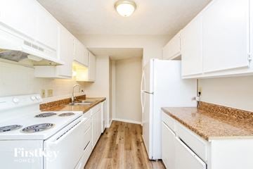 Indianapolis house for rent - A white kitchen with a refrigerator and a stove.