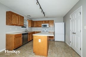 Indianapolis house for rent - a kitchen with wooden cabinets and a white counter top