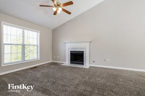 Sugar Hill house for rent - A spacious living room with a fireplace and a ceiling fan.