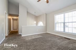 Sugar Hill house for rent - A spacious room with a carpeted floor and a ceiling fan.