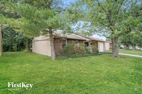 Indianapolis house for rent - A house with a lawn and trees in front of it.