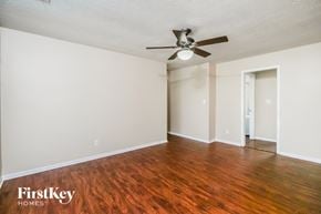 Indianapolis house for rent - A room with a wooden floor and a ceiling fan.