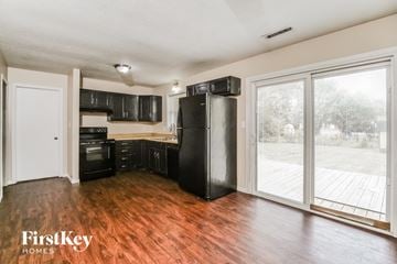Indianapolis house for rent - A kitchen with black appliances and wooden floors.