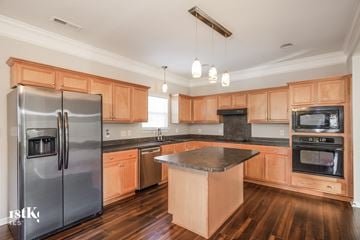 Concord house for rent - a kitchen with wooden cabinets and stainless steel appliances
