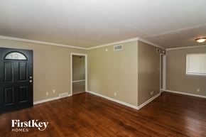 Memphis house for rent - the living room of a house with wooden floors and a black door