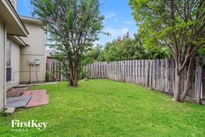 Arlington house for rent - a backyard with a fence and a lawn and trees