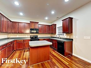 Indian Trail house for rent - A kitchen with wooden cabinets and a center island.
