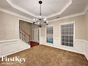 Indian Trail house for rent - A well-lit room with a chandelier and a carpeted floor.