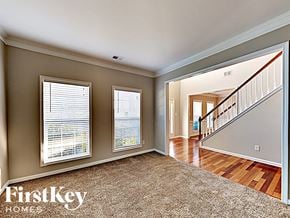 Indian Trail house for rent - A spacious room with a staircase leading to another room.