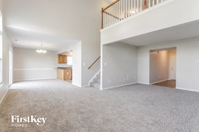 Indianapolis house for rent - A spacious, empty living room with a staircase leading to the upper floor.