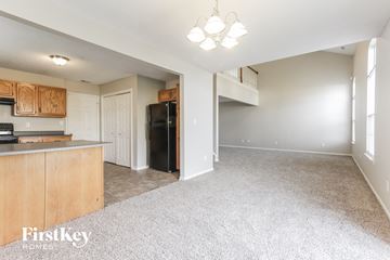Indianapolis house for rent - A kitchen with wooden cabinets and a black fridge is shown.