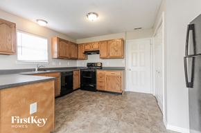 Indianapolis house for rent - A kitchen with wooden cabinets and a black refrigerator.