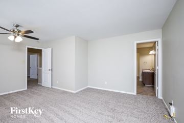 Winston-Salem house for rent - a living room with white carpet and a ceiling fan