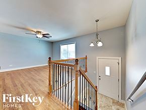 Matteson house for rent - an upstairs landing with a door to the hallway and a ceiling fan