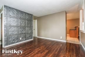 Indianapolis house for rent - A room with wooden floors and a wall of patterned tiles.