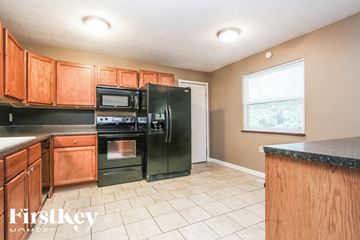 Indianapolis house for rent - A kitchen with wooden cabinets and black appliances.