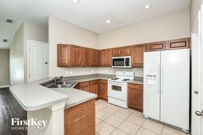 Auburndale house for rent - a kitchen with white appliances and wooden cabinets