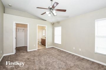 Auburndale house for rent - a living room with carpet and a ceiling fan